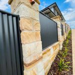 Sandstone Pillar Fence with corrugated iron panels