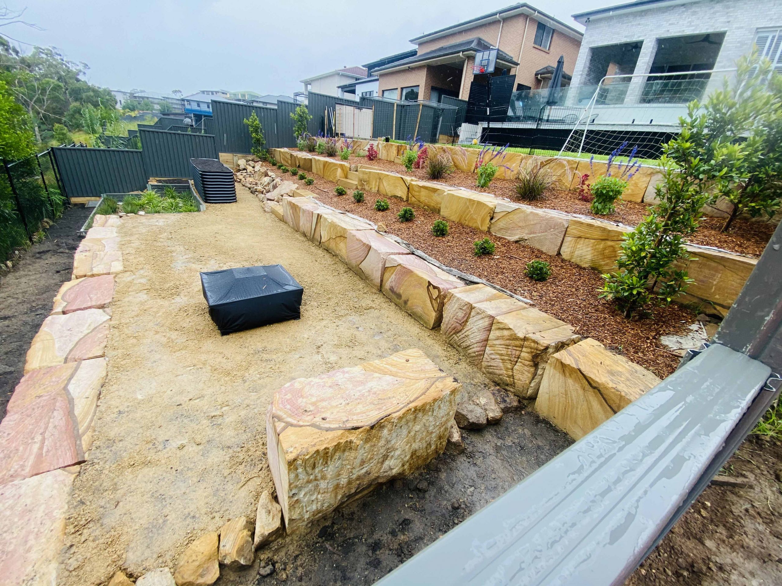 Sandstone log pillar retaining wall – new home landscaping Sydney