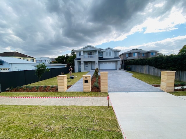 sandstone fence pillar with concrete driveway