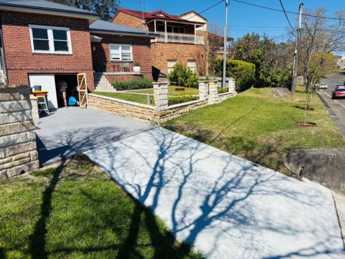 concrete driveway with sandstone retaining wall